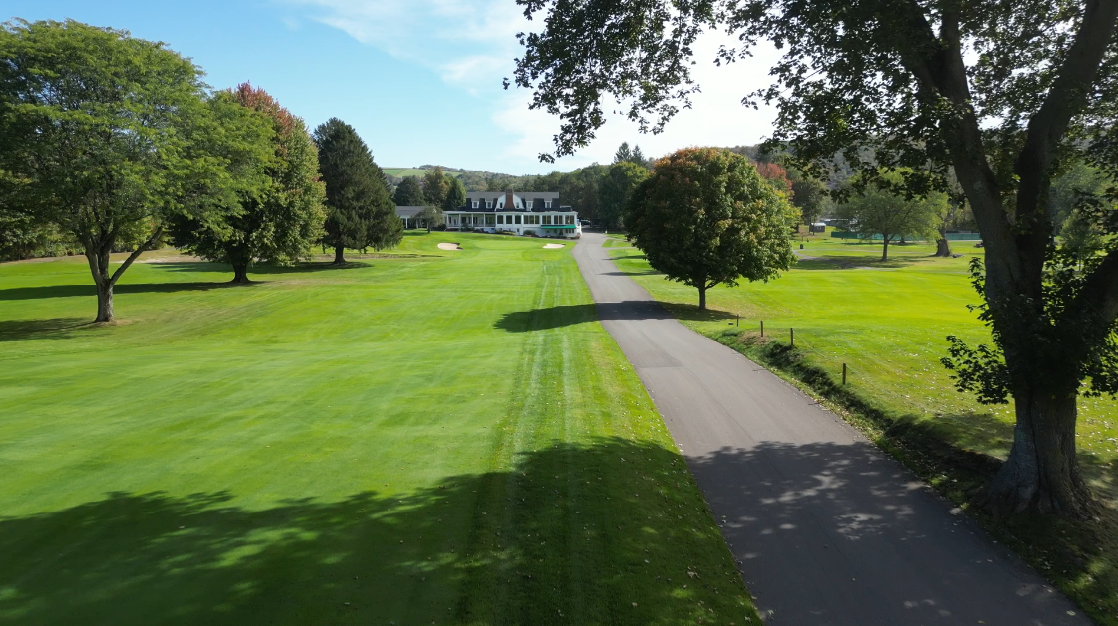 Driveway to the Club House with front green in sight from up in the trees