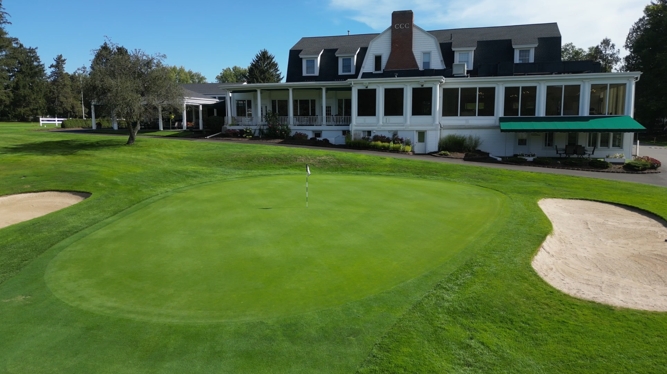 Shot of Front Club House with green centered and bunkers on either side lush green